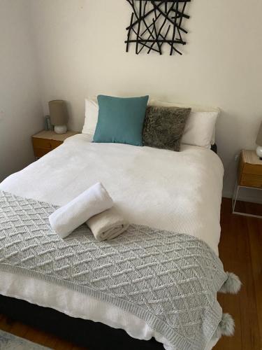 een slaapkamer met een groot wit bed met 2 kussens bij Balcombe Retreat in Mount Martha