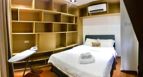 a bedroom with a bed and a lamp and shelves at b.suites 21 in Kota Kinabalu