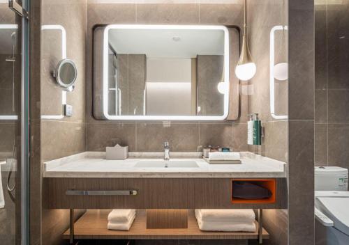 a bathroom with a sink and a mirror at Home2 Suite by Hilton Chongqing South Bank in Chongqing