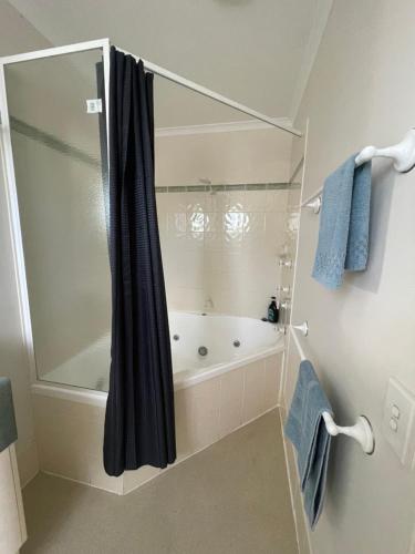 a bathroom with a tub and a shower curtain at Warrego Motel in Charleville