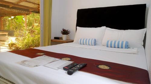 a bedroom with a bed with two remote controls on it at Baywalk Suites Batangas in Laurel