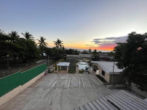 a parking lot with a picnic table and a sunset at Lomeli’s Home, 5 minutos del Tunco in La Libertad