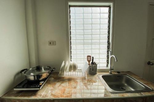 un comptoir de cuisine avec un évier et une fenêtre dans l'établissement House No.2 Village, à Krabi