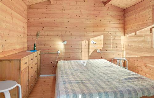 ein Schlafzimmer mit einem Bett in einem Holzzimmer in der Unterkunft Cozy Home In Vggerlse With Wifi in Bøtø By