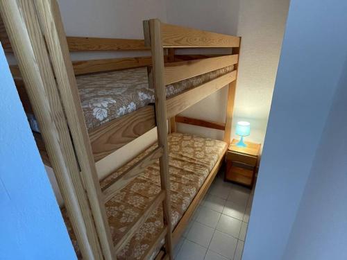 2 Etagenbetten in einem kleinen Zimmer mit einer Lampe in der Unterkunft Appartement Cap d'Agde, 3 pièces, 6 personnes - FR-1-723-54 in Cap d'Agde