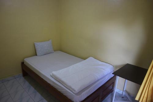 Tange Guest House في روتينج: سرير صغير في زاوية من الغرفة