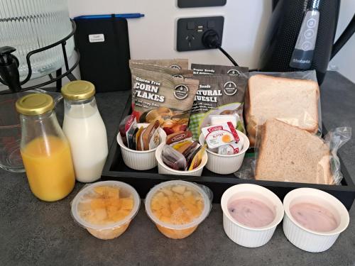 Una bandeja de comida con huevos, pan y leche. en 3 Mile BnB, en Hokitika