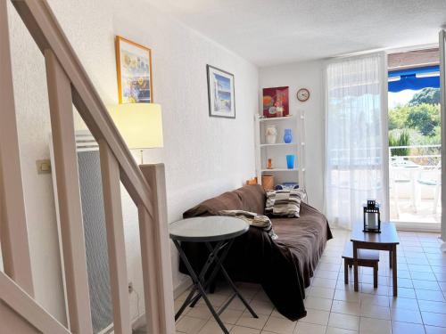 un salon avec un canapé et une table dans l'établissement Duplex ensoleillé avec terrasse, 5 couchages, proche plage, parking inclus - Le Lavandou - FR-1-251-565, au Lavandou