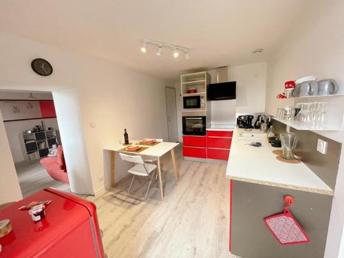 une cuisine avec des armoires rouges et un comptoir blanc dans l'établissement Gîte tout confort avec grand jardin, terrasse ombragée, animaux acceptés, proche de Loches - FR-1-381-560, à Ferrière-Larçon