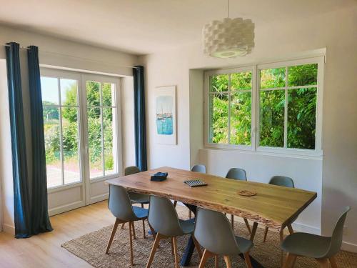 une salle à manger avec une table et des chaises en bois dans l'établissement Maison rénovée avec jardin, proche plage Kerleven, 8 pers, Golf Cornouaille à 1.8 km - FR-1-481-153, à La Forêt-Fouesnant