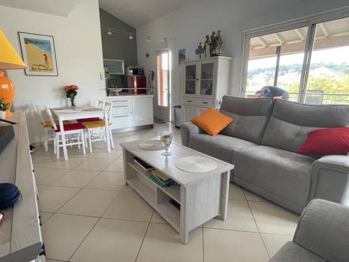 un salon avec un canapé et une table dans l'établissement Appartement 2 chambres + mezzanine, proche plage, climatisé, terrasse, parking réservé - FR-1-768-61, aux Issambres
