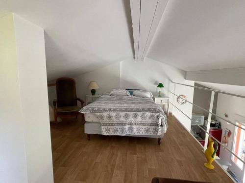 une chambre blanche avec un lit et une chaise dans l'établissement Appartement 2 chambres + mezzanine, proche plage, climatisé, terrasse, parking réservé - FR-1-768-61, aux Issambres