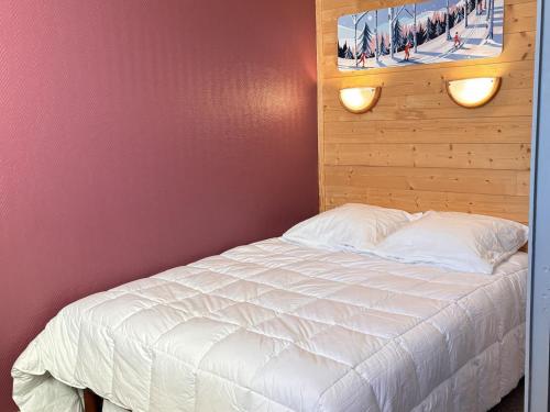 1 dormitorio con cama blanca y cabecero de madera en Appartement Avoriaz, 2 pièces, 4 personnes - FR-1-634-99, en Morzine