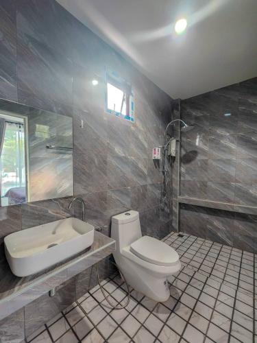 a bathroom with a toilet and a sink at วาญ่า พูลวิลล่า สัตหีบ in Ban Khlot