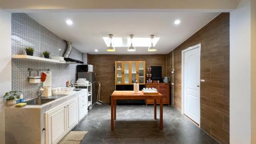 a kitchen with a table and a sink at Neveu Premier Residence : Ratchada in Bangkok