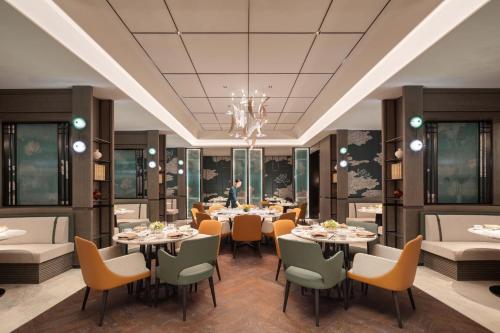 a rendering of a restaurant with tables and chairs at Crowne Plaza Jinan Runhua by IHG in Jinan