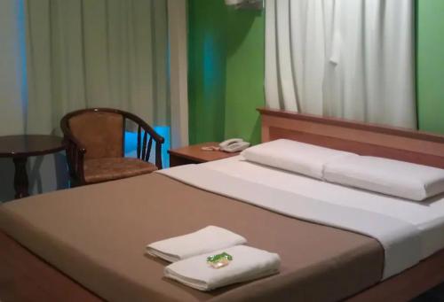 a bedroom with a bed with two towels on it at Hotel Western in Sandakan