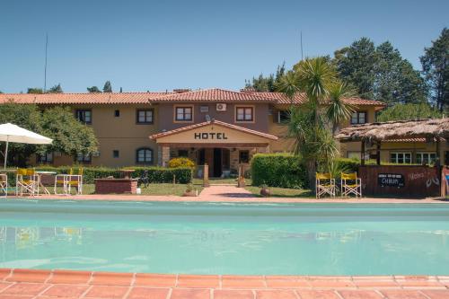 um hotel com piscina em frente a um edifício em Hotel Lago Los Molinos em Villa Ciudad de America