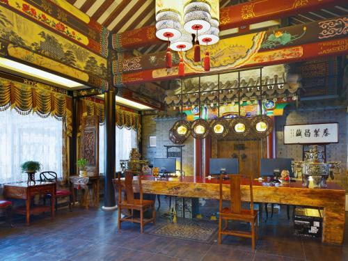 a restaurant with a bar and tables and chairs at Datong Yunzhong Traditional Courtyard in Datong