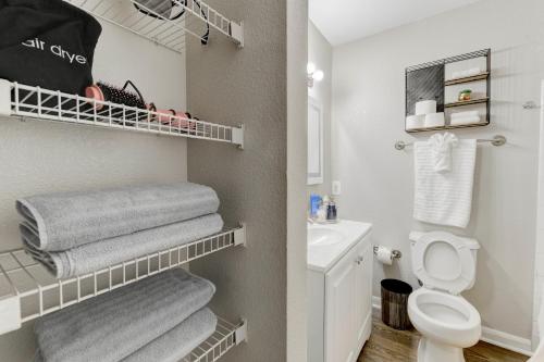 a bathroom with a white toilet and towels at Comfy& stylish ~2bed~2Bath ~8 minute to Downtown in Austin
