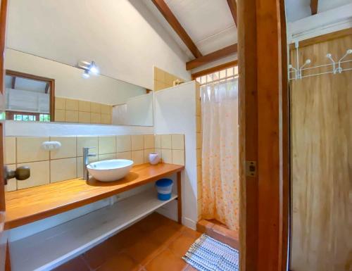 y baño con lavabo y espejo. en Hotel Casitas Mar y Luz, en Puerto Viejo