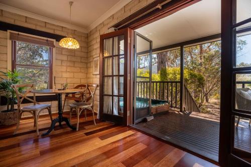 a room with a balcony with a table and chairs at Maya Sanctuary in Little Hartley