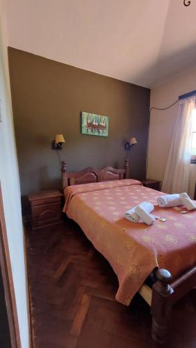 Schlafzimmer mit einem Bett mit rosa Tagesdecke in der Unterkunft Hotel Lago Los Molinos in Villa Ciudad de America