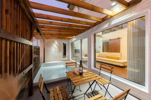 a house with a pool and a table and chairs at Tov & Kara in Jeju