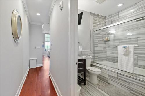 ein weißes Bad mit einem WC und einer Badewanne in der Unterkunft Comfy Apt, Rooftop Pool & Deck & Amenities in Philadelphia
