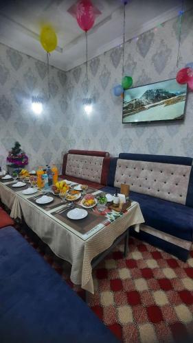 a dining room table with food and plates on it at Зона отдых APACHI в горах ЧИМГАН in Chimgan
