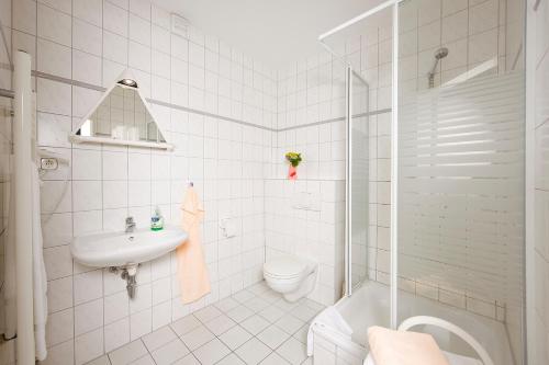 a white bathroom with a toilet and a sink at Zum Alten Schweden in Wolgast