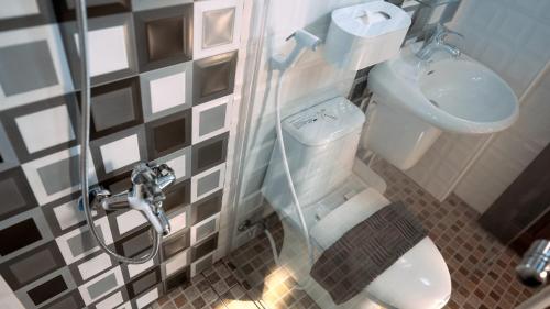 a bathroom with a shower and a toilet and a sink at 咻咻宿 Xiuxiu 電梯宅 in Taitung City