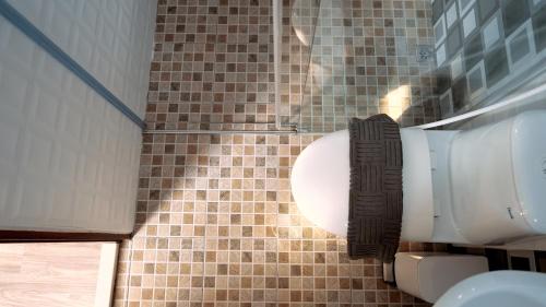 a bathroom with a toilet and a tiled wall at 咻咻宿 Xiuxiu 電梯宅 in Taitung City