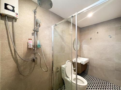 a bathroom with a shower with a toilet and a sink at Neveu Premier Residence : Ratchada in Bangkok