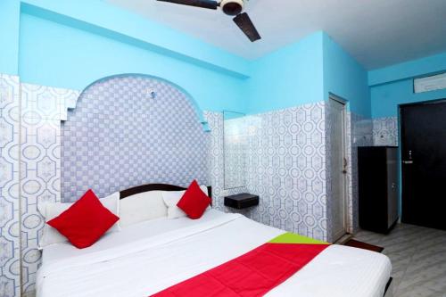 um quarto com uma cama branca e almofadas vermelhas em Goroomgo Shree Bhumi Puri Near Sea Beach - Best Hotel in Puri em Puri