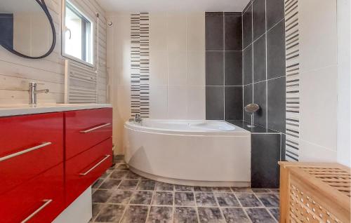 uma casa de banho com uma banheira branca e um armário vermelho em Gorgeous Home In Le Tour-du-parc With Wi-fi em Le Tour-du-Parc