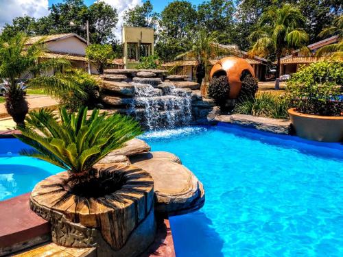 einen Pool im Hinterhof mit einem Wasserfall und einem Brunnen in der Unterkunft Resort Campo Belo in Álvares Machado
