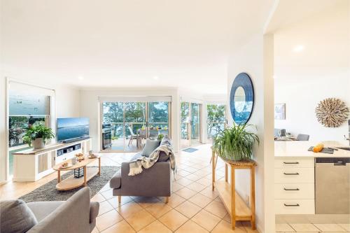 a living room with a couch and a table at Danalene, 44a Danalene Pde - stunning waterfront property with Air Con, WI-FI, Double Lock Up Garage & Boat Parking in Corlette