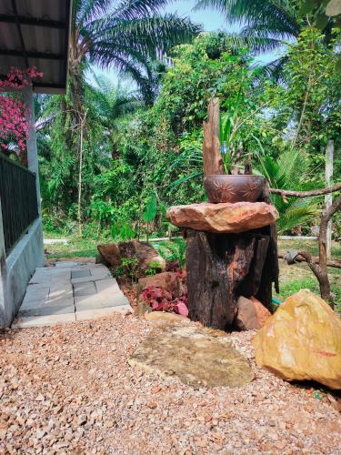 a bench made out of a tree stump at Baan Namthip Homestay Trang บ้านน้าทิพย์ โฮมสเตย์ตรัง in Ban Huai To (1)