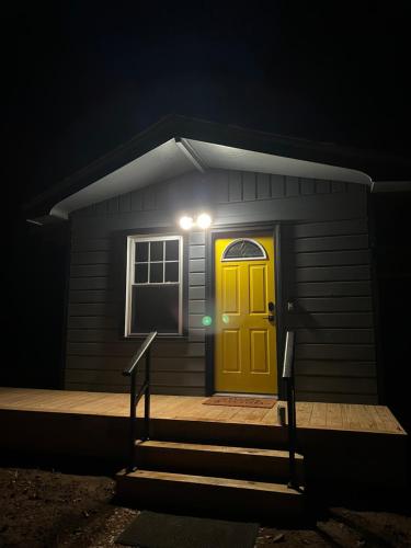 a house with a yellow door at night at Chalet 86 - 3 Minutes From Whiteface Mountain in Wilmington