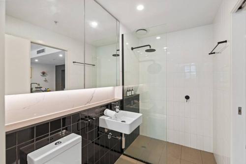 een badkamer met een wastafel, een toilet en een spiegel bij Southbank One Bedroom Home with Free Parking in Brisbane