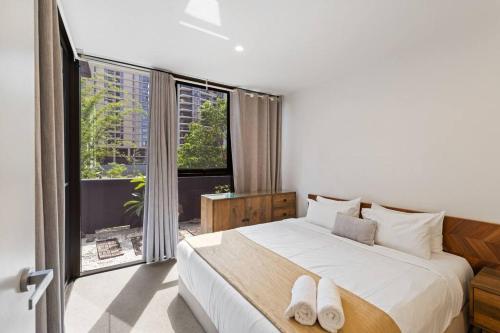 a bedroom with a large bed and a large window at Southbank One Bedroom Home with Free Parking in Brisbane