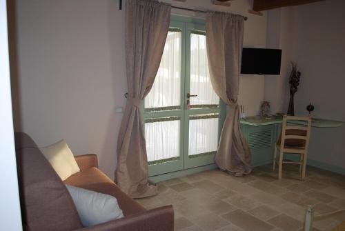 a living room with a large window and a desk at Le Maraclà Country House in Iesi