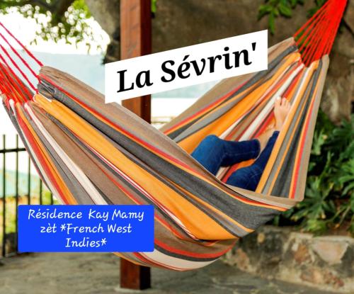 a woman is sleeping in a hammock at Résidence Kay Mamy Zèt in Le François