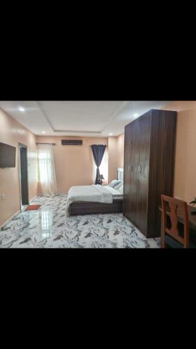 a bedroom with a bed and a dresser in it at 6A Resort LTD in Owerri