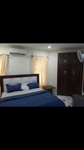 een slaapkamer met een blauw bed met blauwe kussens bij 6A Resort LTD in Owerri