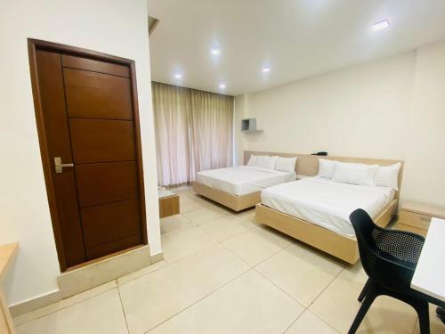 a hotel room with two beds and a desk at Mount view by farstay in Wayanad