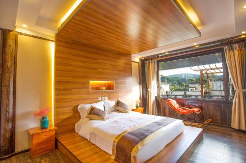ein Schlafzimmer mit einem großen Bett und einem großen Fenster in der Unterkunft Tengchong Old Town Peace Inn in Tengchong