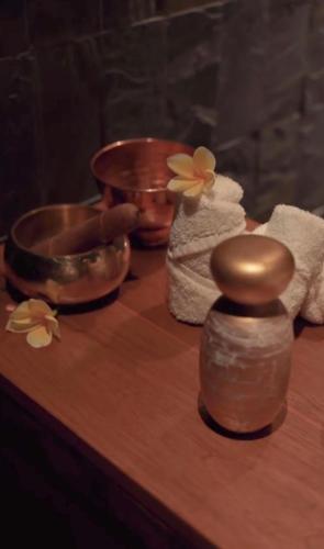 a wooden table with towels and a bowl and a wooden table at La Reserve 1785 Canggu Beach - Adults Only in Canggu
