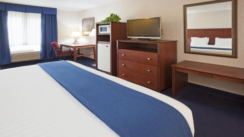 a hotel room with a bed and a desk and a television at Holiday Inn Express Deforest, an IHG Hotel in De Forest